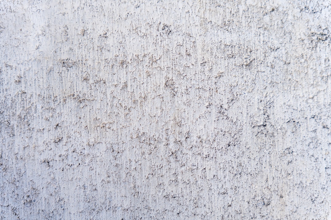 a close up of a white wall with small black dots