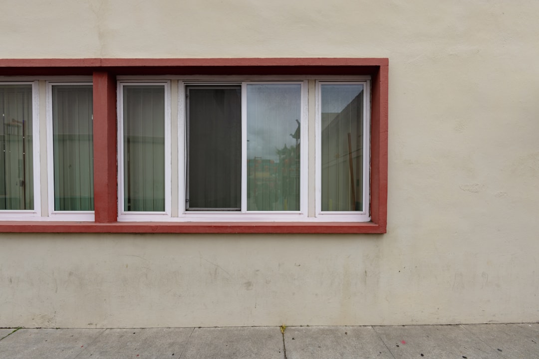 A window with a red frame on a tan wall.
