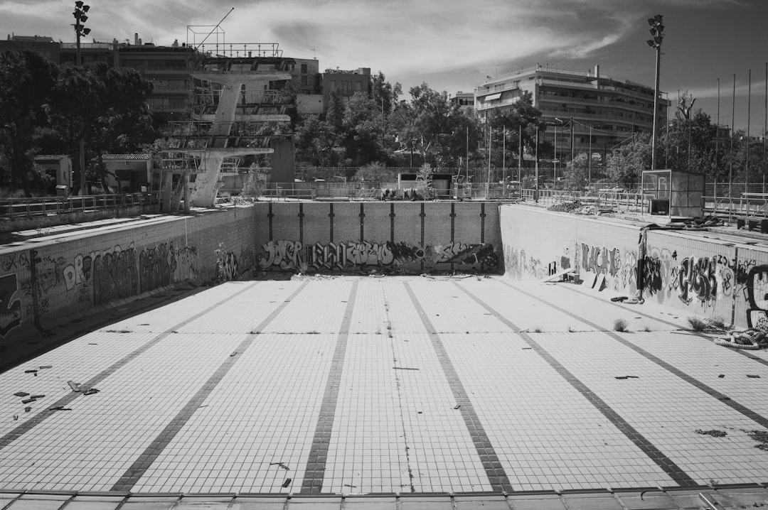 An abandoned swimming pool is empty and depressed.