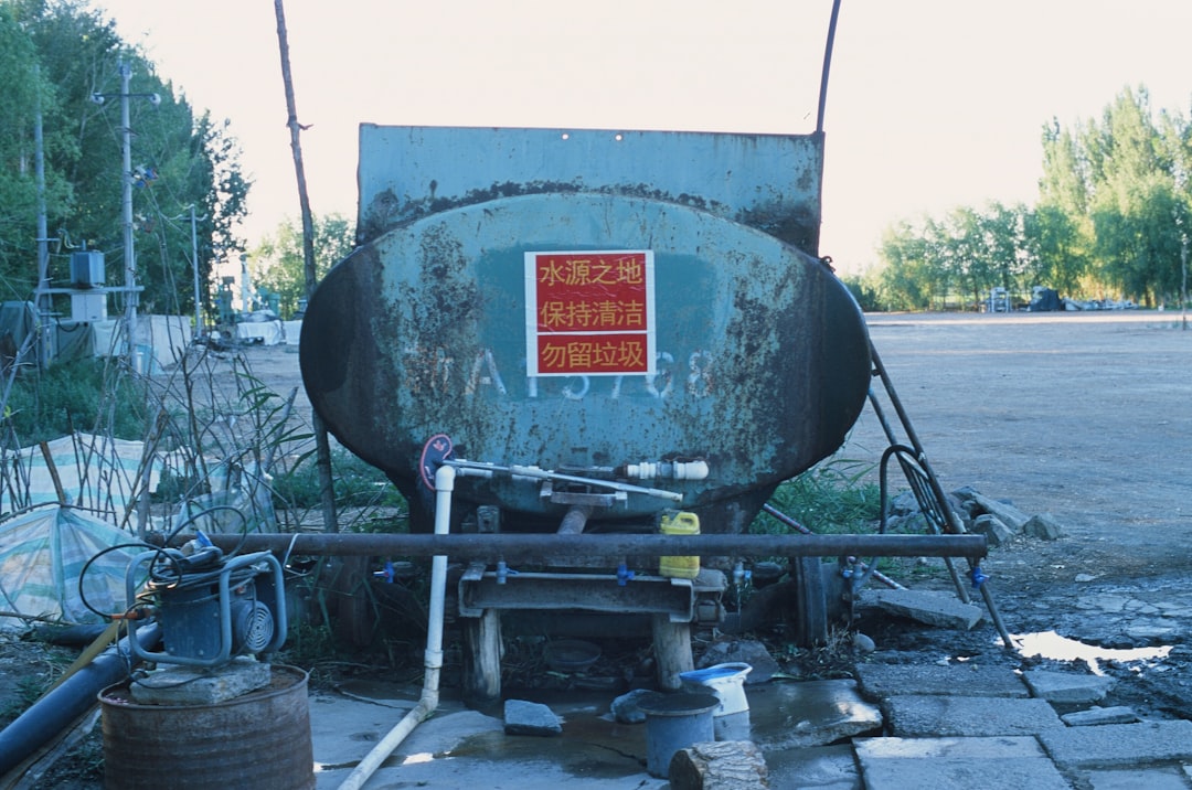 A large green tank sitting on the side of a road