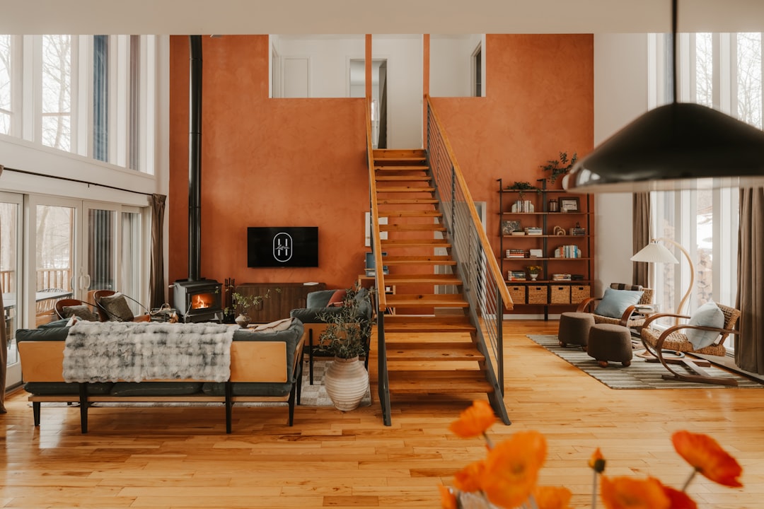 Spacious modern living room with wooden staircase and fireplace.