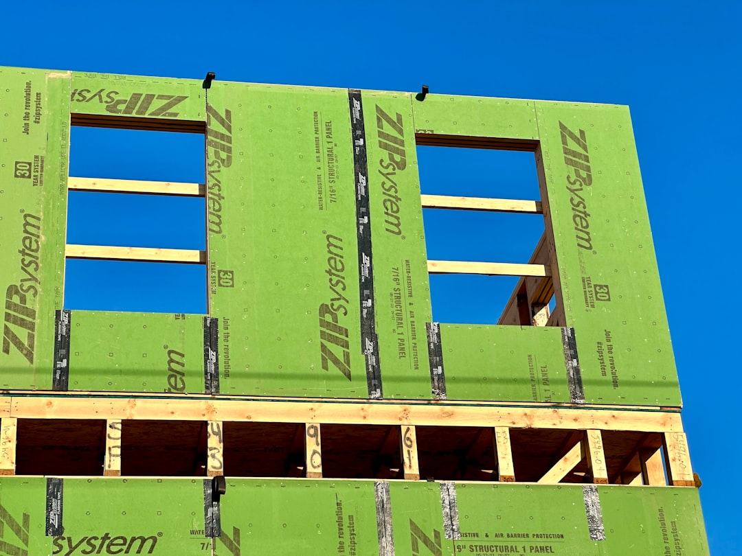 a green building under construction with a blue sky in the background